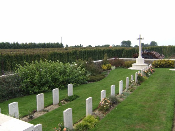 Rue-du-Bacquerot No 1 Military Cemetery with rows of gravestones leading to the Cross of Sacrifice