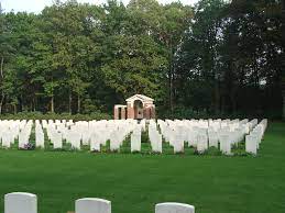 Photo of Leopoldsburg War Cemetery. Rows of headstones in front of a line of trees.