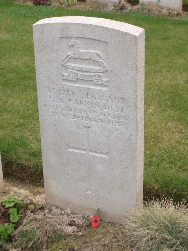 harry benfield parkin's white gravestone with his regimental badge, name and date of death inscribed together with a cross