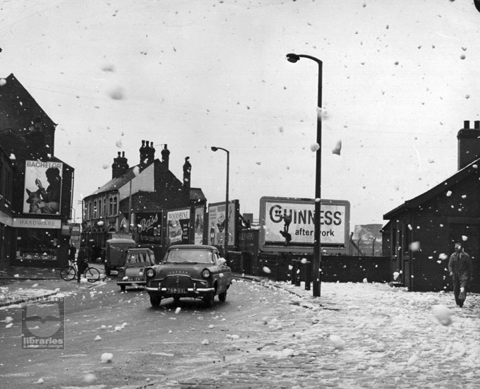 Foam pollution on Aire Street, Castleford, 1950s A black and white photograph taken from outside Allinson's Flour Mill, on Aire Street, Castleford, looking towards Savile Road. The wind is blowing foam from the river to the street. Parkins' hardware shop is on one corner and opposite The Crimea public house. Internal Reference: CA YILLUS 1152