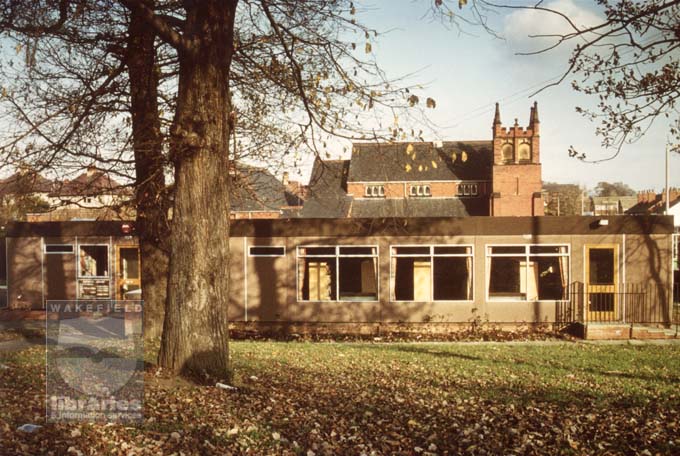 A colour photograph of Outwood Library taken from Victoria Street.  The library was built in 1983 to replace unsatisfactory buildings at Newton Hill and Lofthouse Gate branch libraries.  Houses can be seen in the background, including those on Leeds Road on the right.  In the centre background stands Outwood Methodist Church.
