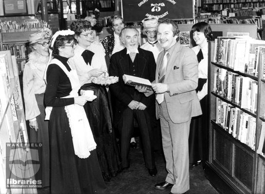 75th Anniversary of Drury Lane Library, Wakefield A black and white photograph of the 75th anniversary of Drury Lane Library, Wakefield. A group of staff pose by the bookshelves. The man holding the book is Councillor J.D.Pearman.