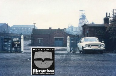 A colour photograph of the entrance to Upton Colliery. A car is parked near the entrance. Internal Ref: Private collection
