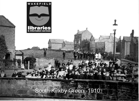 A black and white photograph of a large crowd of children standing at The Green, South Kirkby. Photograph taken in 1910. Various houses and the school can be seen on Lidgate. Internal Ref: Private collection
