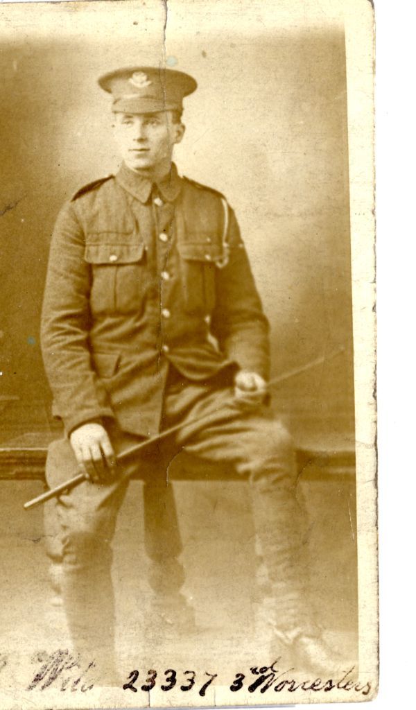 john wearing his army uniform sitting on a fence