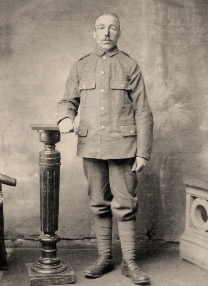 John Asquith, in uniform, standing next to a lectern