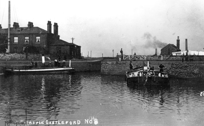 A black and white photograph of the lock on the Aire and Calder Navigation at Lock Lane, Castleford.  Two steam barges are waiting to enter and people are on the barges and tow paths.  Internal Reference: CA YILLUS 3707