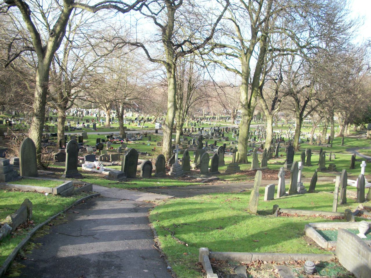 Pontefract Cemetery with a path going downhill past gravestones